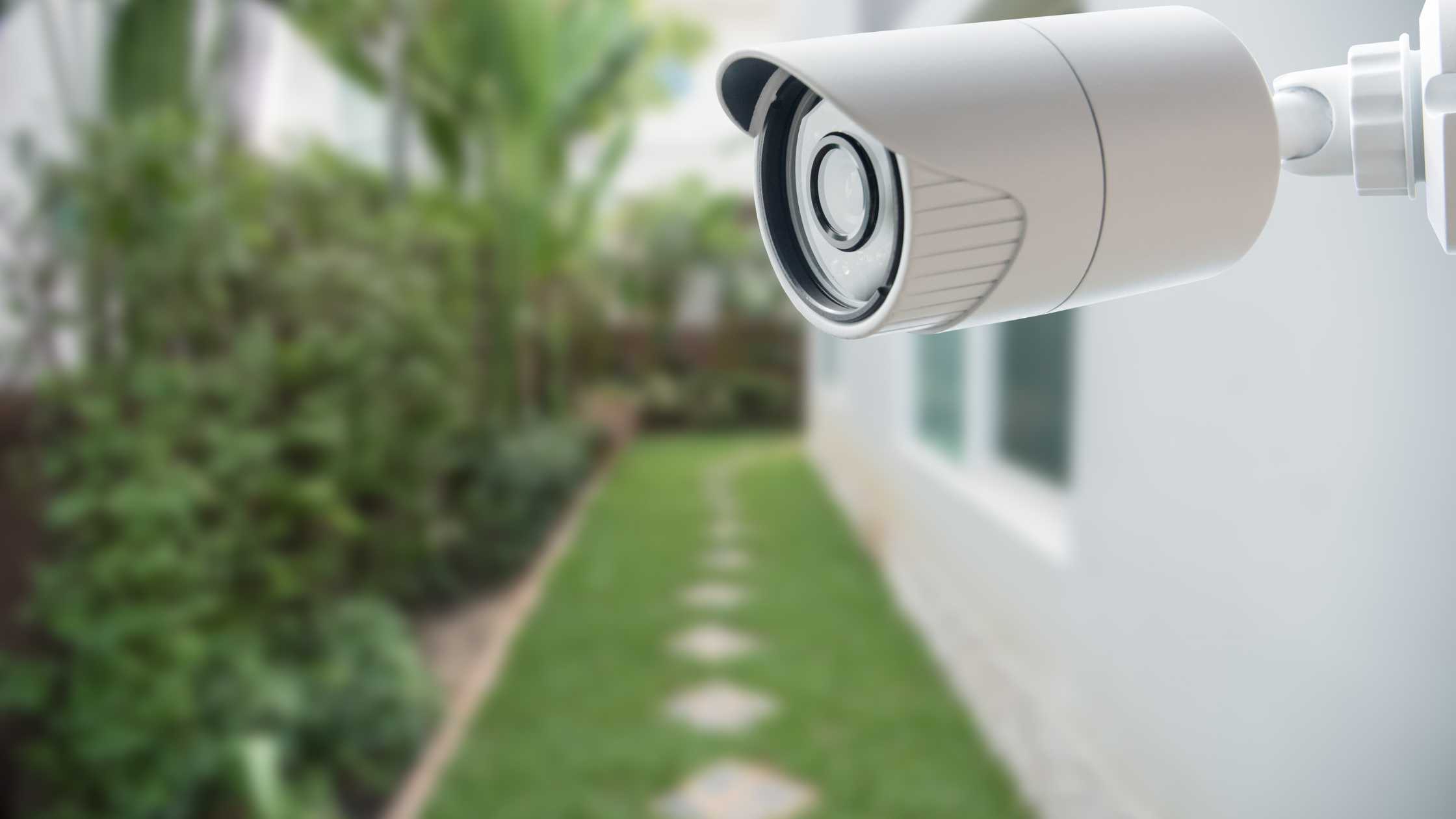 Security camera monitoring a garden pathway, emphasizing home safety and surveillance solutions.