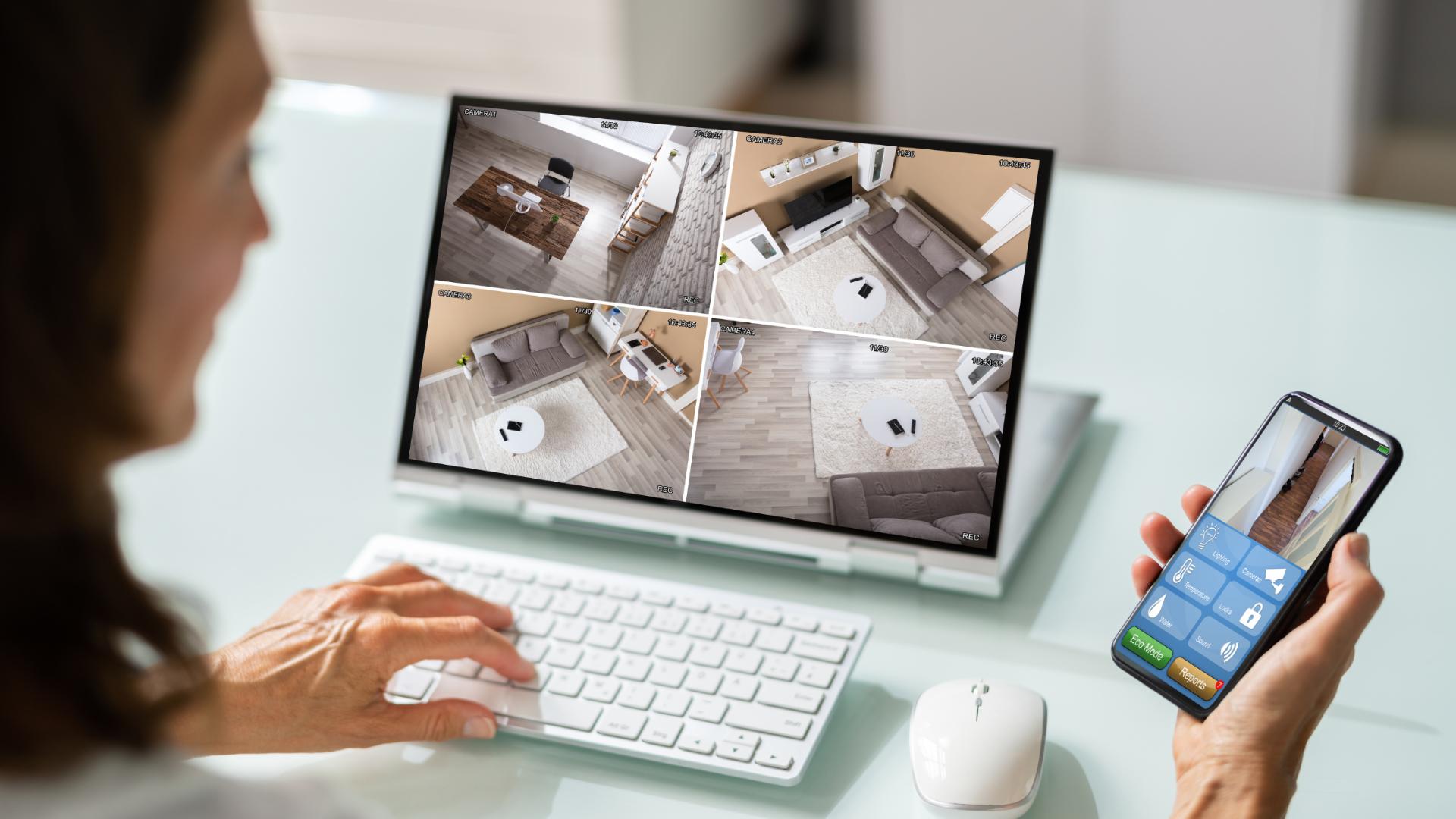 Woman monitoring CCTV feeds on a computer screen and smartphone, showcasing smart security camera installation for home security.